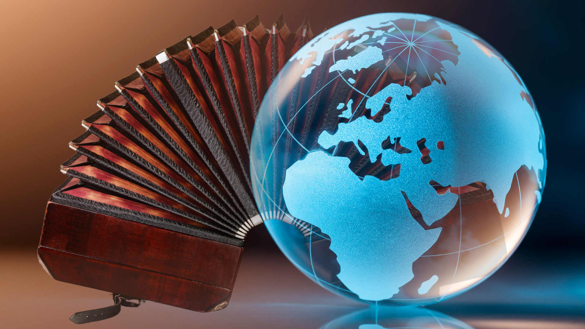 A bandoneon placed next to a globe, symbolizing its German origin and worldwide journey into tango.